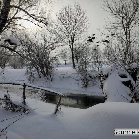 Flußlandschaft im Winter am Abend mit viel Schnee